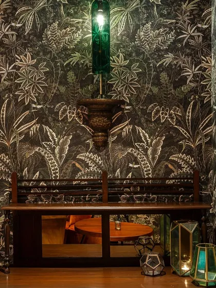 A quiet corner of our Gurugram location, featuring intricate wallpaper and unique lighting. Every detail is thoughtfully designed to create a rich, layered atmosphere.