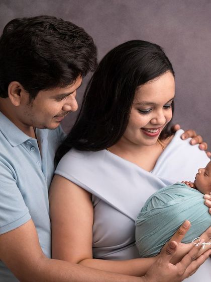 A classic family portrait with new parents adoring their sleeping newborn. These timeless images are treasures for a lifetime.