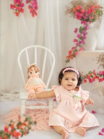 This little girl is reaching out from her chair, full of curiosity at her ten-month photoshoot. I love capturing their growing independence.