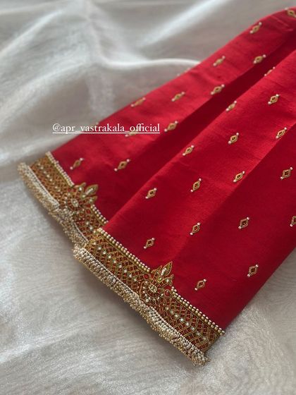 A simple yet elegant red blouse with a delicate embroidered border on the sleeves and neckline.