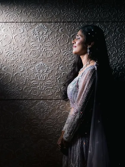 We love playing with light to create something dramatic and different. This artistic bridal portrait uses a single beam of light to highlight the bride's serene expression and the beautiful texture of her gown.