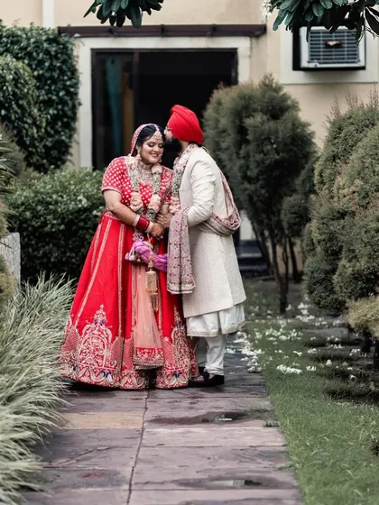 A tender moment where the groom whispers to his bride. This quiet, intimate interaction, captured outdoors, tells a story of their close bond and shared secrets on their wedding day.