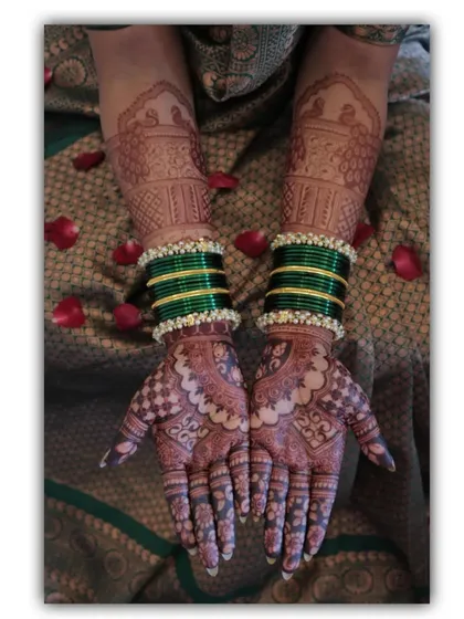 A beautiful shot of a bride's hands, adorned with green bangles that perfectly complement her mehendi. This photo was taken by a professional photographer, capturing the art beautifully.
