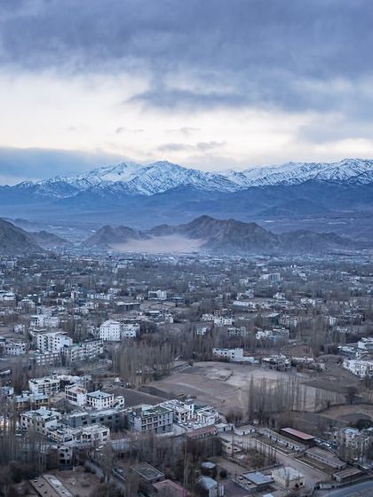 A duplicate of image 48, an aerial view of the city of Leh, nestled in the valley with the snow-capped Himalayas in the background.