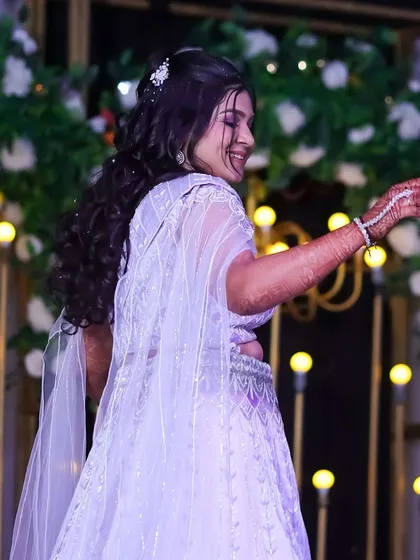 A candid moment of the bride dancing at her Sangeet. The makeup is designed to be long-lasting and photo-ready, even during high-energy performances.