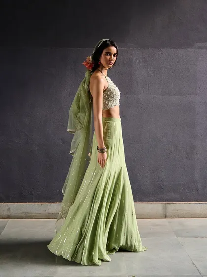 A full-length view of the mint green sharara set from Chamee and Palak. The flowing pants and embellished top create a look that is both elegant and comfortable.