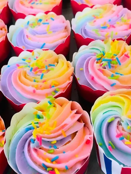 Our signature rainbow cupcakes are always a hit. This close-up shows the vibrant, multi-colored frosting and fun sprinkles that make them perfect for any celebration.