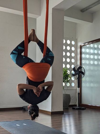 A heart opener from an inverted position. This student is finding a moment of peace and gratitude while hanging upside down.
