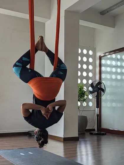 An inverted pose in the aerial hammock, bringing a new perspective and a rush of revitalizing energy.