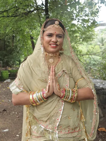 The traditional 'namaste' pose, showcasing the intricate hand jewelry and the bride's serene expression.