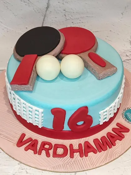 Game, set, match! This table tennis themed cake was made for a 16th birthday. It features edible paddles and balls on a light blue 'table' with a net around the side.