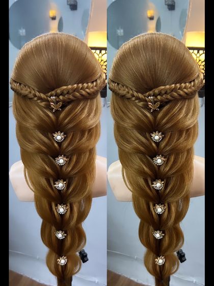 A beautiful braid look with a crown braid and a voluminous lower section, adorned with floral accessories.