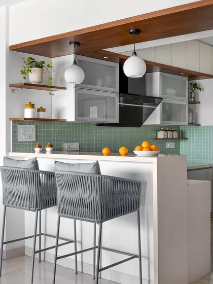 The open-plan kitchen in the 'Gulmohar' project features a breakfast bar that overlooks the dining area, encouraging interaction and creating a social hub.