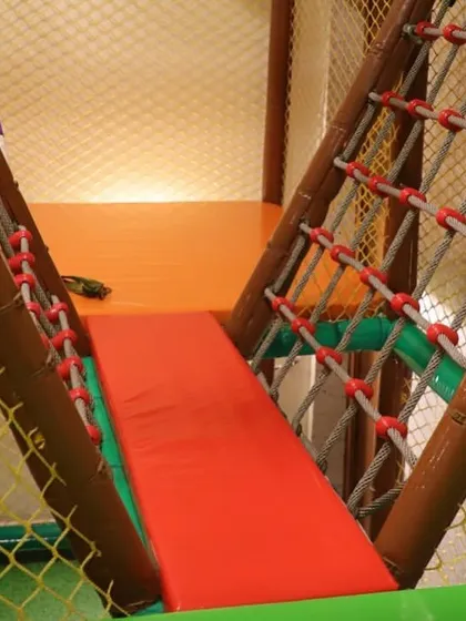 A view of the rope bridge, part of the multi-level climbing structure. It offers a fun challenge for kids as they navigate the play gym.