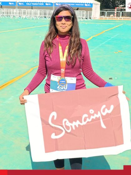 Dr. Vrushali Deole holds the Somaiya flag after successfully completing the 42 km Bajaj Pune Marathon 2025.