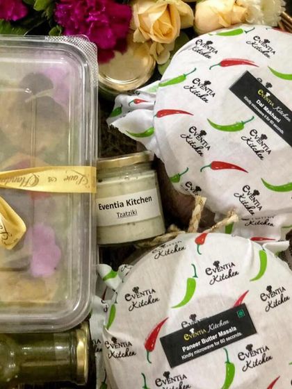 A complete meal hamper showing how different dishes like Dal Makhani and Paneer Butter Masala are packed alongside appetizers and dips. This is part of my service to provide a full, cohesive dining experience.