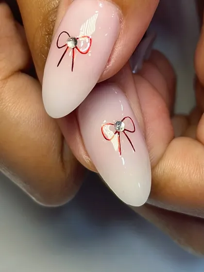 A close-up of the delicate red bow art, finished with a tiny rhinestone for a touch of sparkle.