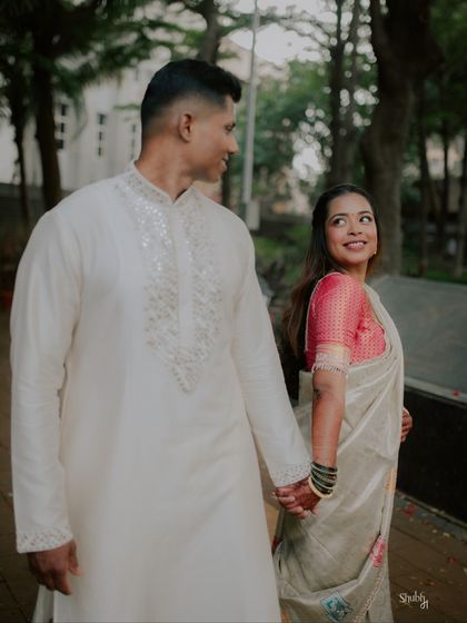 The couple shares a look of love as they walk together. This candid photo captures the natural chemistry and happiness of their engagement day.