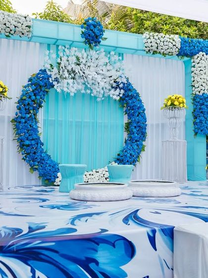A closer view of the blue and white floral ring backdrop. This modern design element adds a unique touch to the Haldi stage, showing our ability to work with unconventional color palettes.