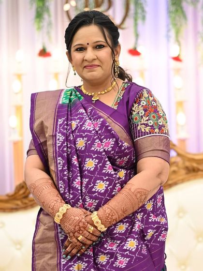 The groom's mom looking elegant in her purple saree, with the rich stain of her mehendi beautifully complementing her look.