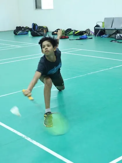 A young player demonstrates a perfect lunge to play a low shot, a result of our rigorous footwork and flexibility training.