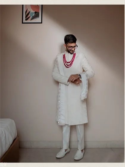 The groom checks his watch, a classic pose captured with dramatic lighting.