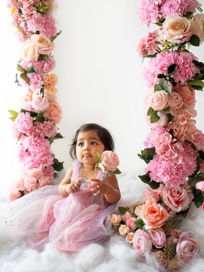 A thoughtful moment, holding a single rose. The variety of pink and peach flowers creates a beautiful, soft color palette.