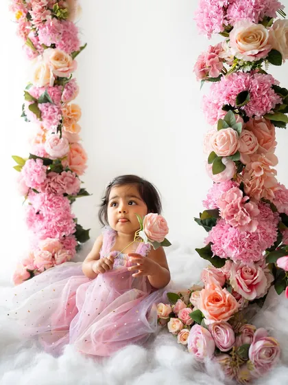 A thoughtful moment, holding a single rose. The variety of pink and peach flowers creates a beautiful, soft color palette.