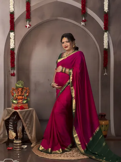 A stunning solo portrait in the vintage arch setup. The rich colors of the saree and the traditional decor create a timeless image.