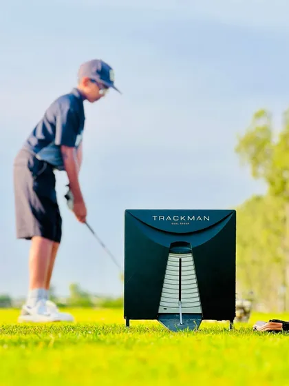 Early morning sessions often involve the TrackMan. Here, a junior golfer is working on his swing, with every shot captured and analyzed. This disciplined, data-backed approach is how we build consistency from a young age.