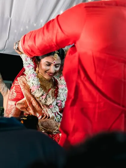 A candid shot of a Bengali bride during the 'Shubho Drishti' ritual.