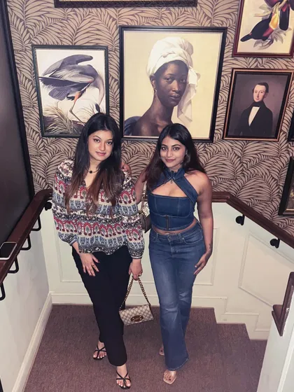 A photo with a friend on a beautifully decorated staircase. My denim outfit stands out as a modern, casual choice for a night out.