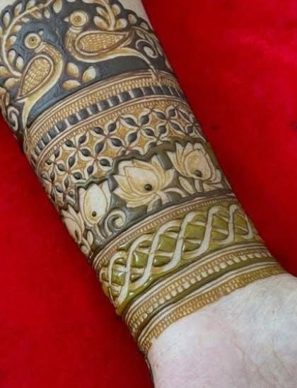 The completed armband, with the bird motif at the top and intricate bands of lotus and geometric patterns below.