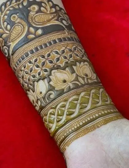 The completed armband, with the bird motif at the top and intricate bands of lotus and geometric patterns below.