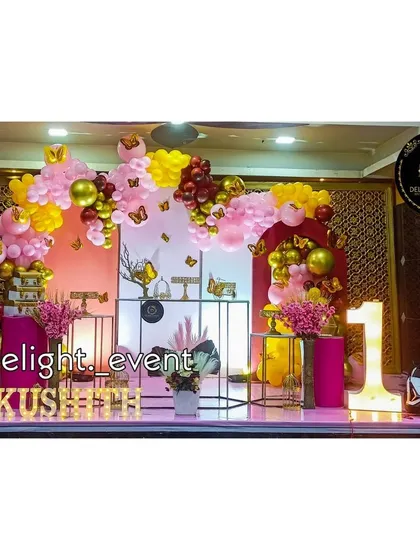 We love bringing big themes to life, like this butterfly-themed first birthday party. This grand setup includes a multi-colored balloon arch, decorative pedestals for the cake, light-up letters for the baby's name, and a large marquee number '1'.
