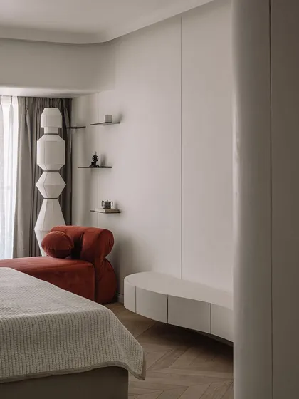 A rust-colored chaise lounge adds a pop of color to the neutral master bedroom. It’s the perfect spot to relax and enjoy the play of shadows from the Champa tree outside.