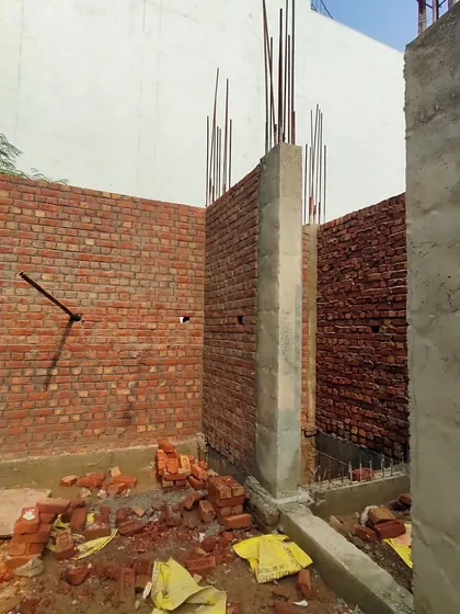 An image from an ongoing residential site visit for a 150 sq. yard plot. This shows the initial stages of construction, with brickwork and reinforced concrete columns forming the ground floor structure.