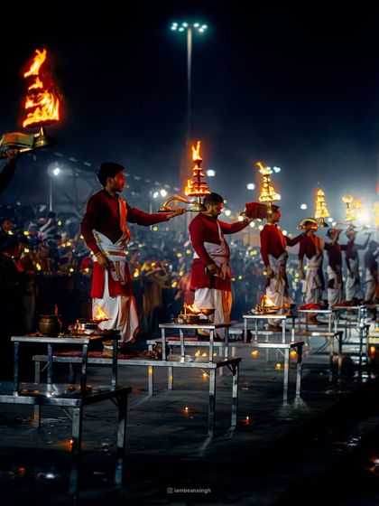 Priests perform the synchronized Ganga Aarti ritual in Rishikesh. The fire, the smoke, and the coordinated movements create a powerful spectacle of devotion against the dark night.