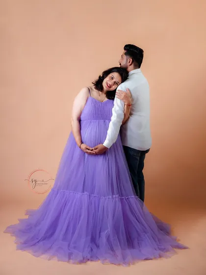 A serene portrait of an expecting mother leaning on her partner. The soft lighting and her gentle smile create a feeling of peace and contentment during her pregnancy journey.