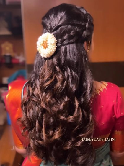 A clear, still image of the half-up style with a braid and curls, a very popular choice for engagements.
