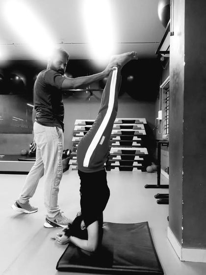 Even coaches need a support system. Here I am getting assistance with a headstand to ensure proper alignment and safety.