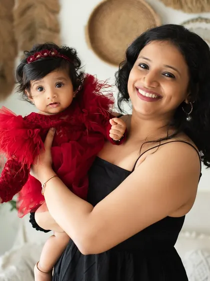 A mother holds her beautifully dressed baby girl. This portrait from a themed session shows the pride and joy a mom feels for her little one.