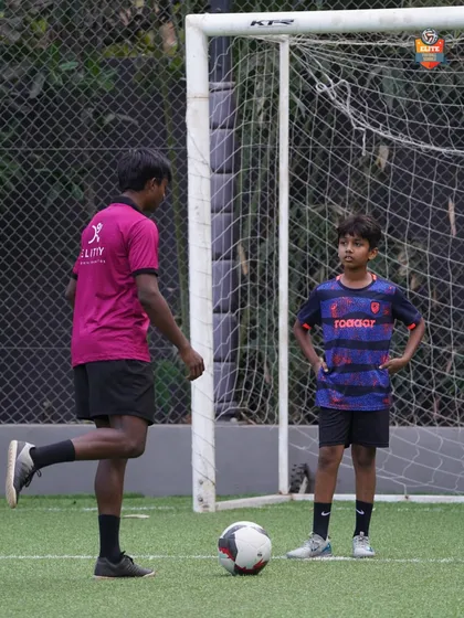 A coach demonstrating proper technique to a young player. Our 1-on-1 sessions are tailored to address specific areas of improvement.