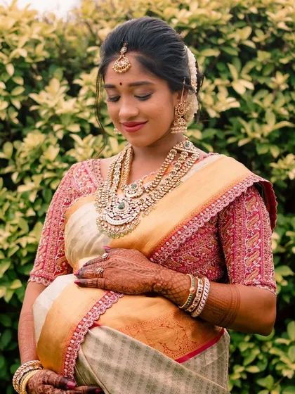 Celebrating a special milestone with a custom maternity occasion wear outfit. This expecting mother is glowing in a bespoke Kanchipuram silk saree and an intricately embroidered pink blouse designed for comfort and elegance during her baby shower.