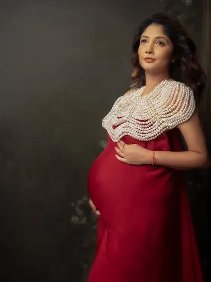 A regal portrait in red, adorned with a statement pearl collar. This look is for the mama who wants to feel like a queen.