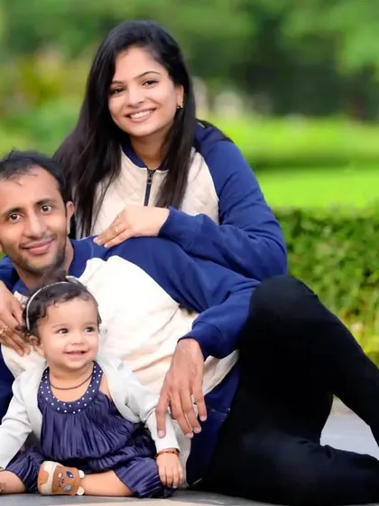 A relaxed family portrait taken in a local park, with parents and their young daughter sitting together. We find the best spots with soft, natural light to create warm and inviting family photos.