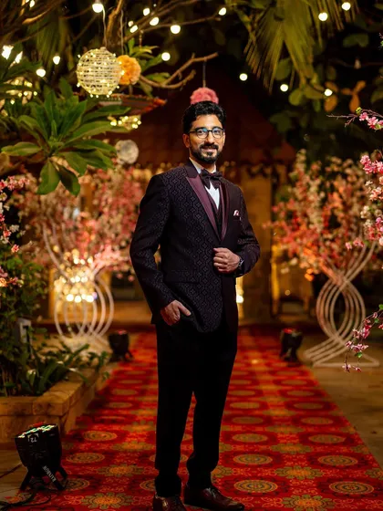 The groom looking dapper and ready for the reception party, posing on the red carpet entrance.