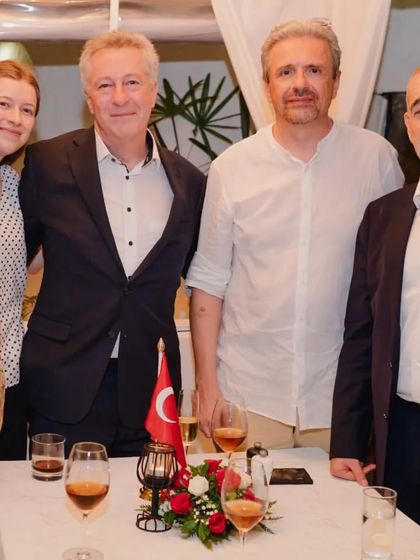 A group of guests posing for a photo at their table during a special event.