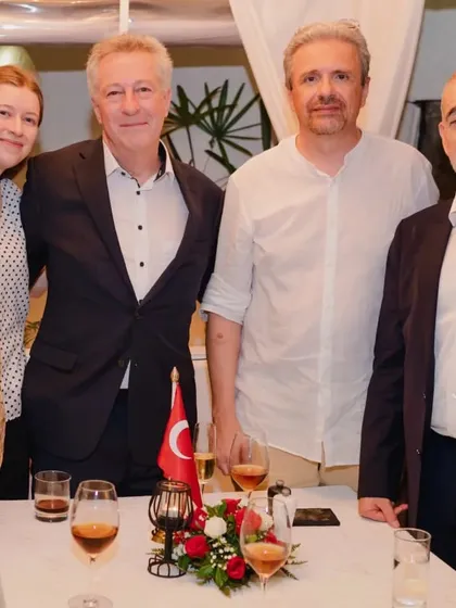 A group of guests posing for a photo at their table during a special event.