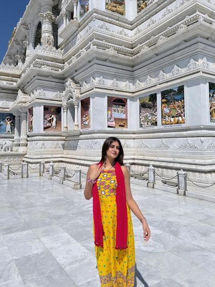 Another beautiful shot at Prem Mandir, showcasing the flowy silhouette of the yellow suit against the white marble architecture.